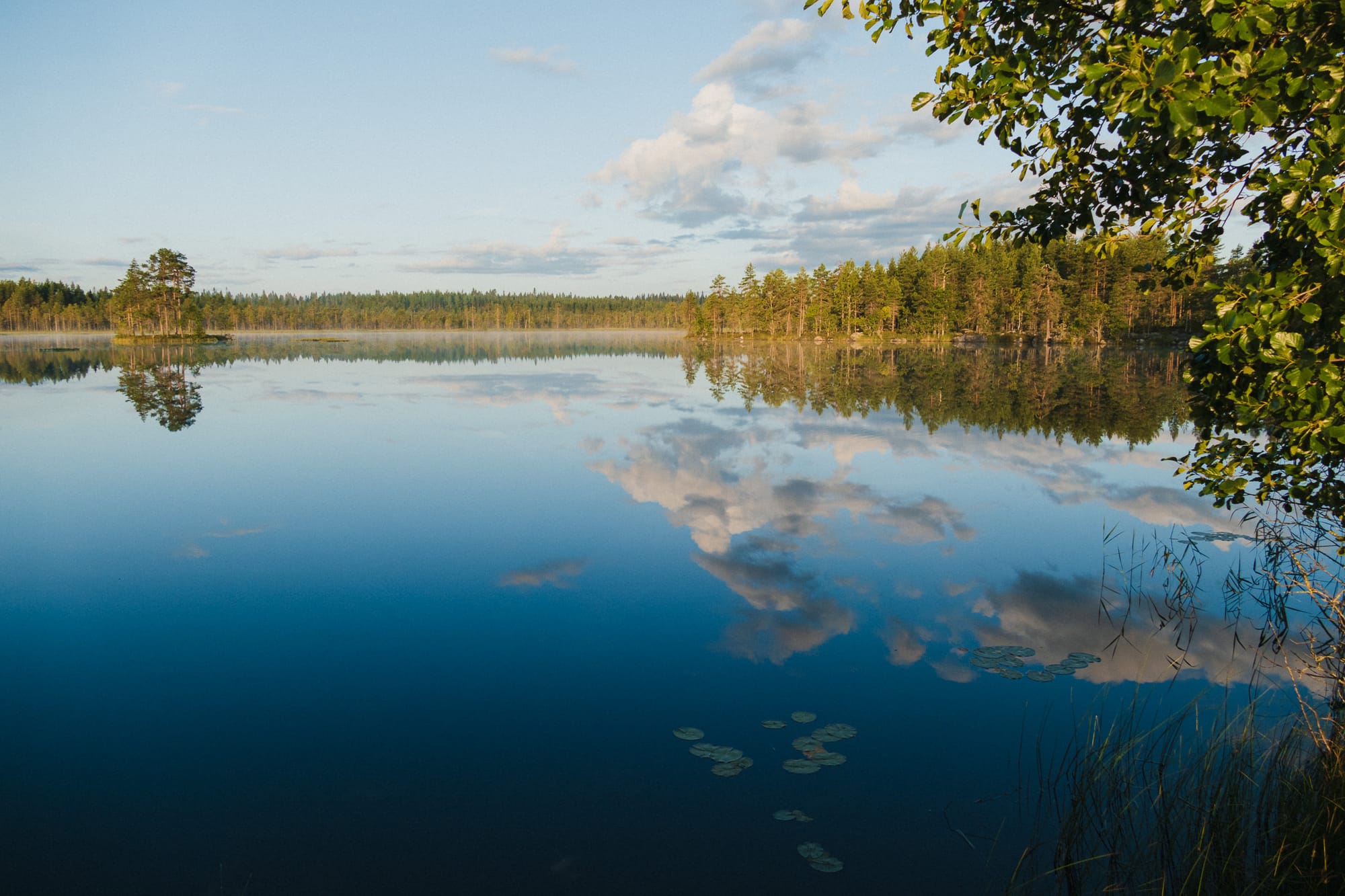 See mit spiegelnden Wolken